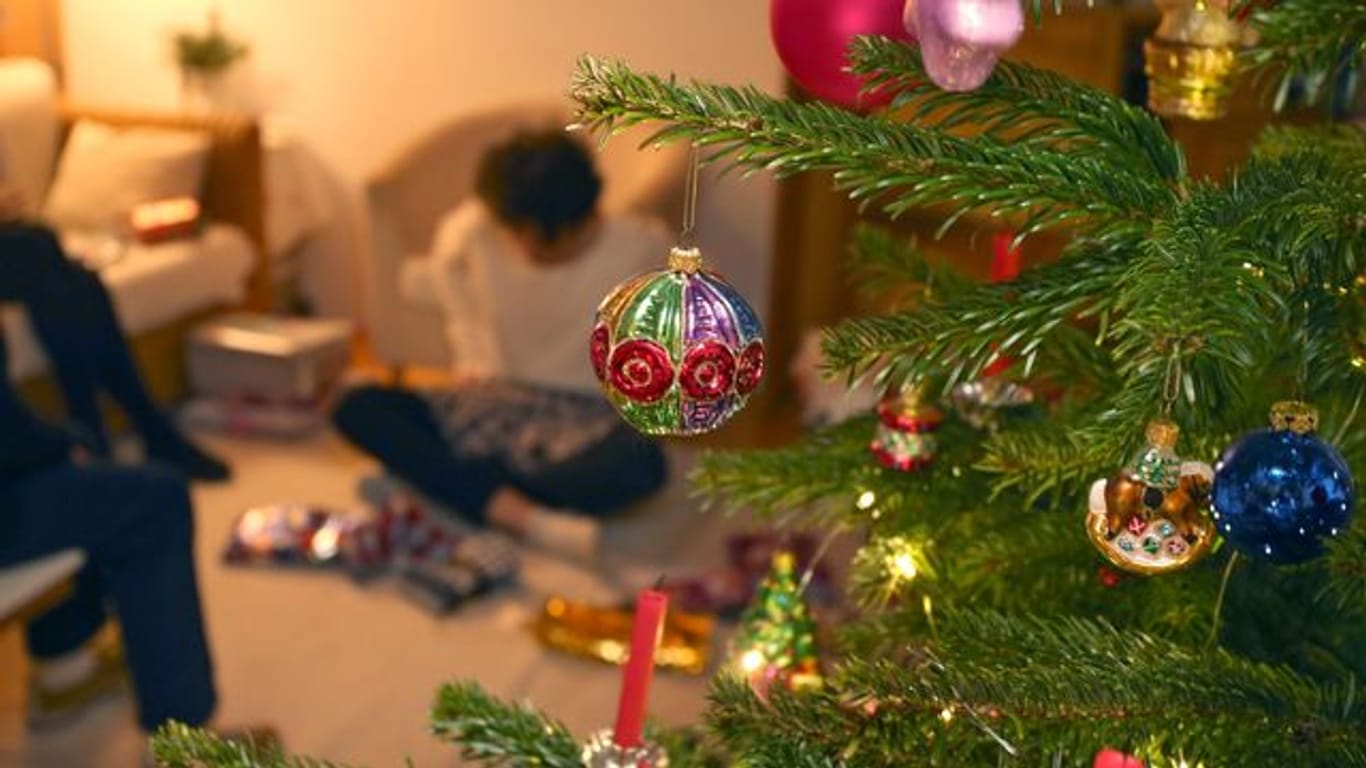 Auch im Corona-Jahr sollen Familien unter einem geschmücktem Weihnachtsbaum gemeinsam Geschenke auspacken können.