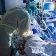 Ein Mitarbeiter in einem deutschen Krankenhaus bei der Behandlung eines Corona-Patienten (Symbolbild): Dubiose Vermittler nutzen den Personalnotstand in der Pandemie aus.