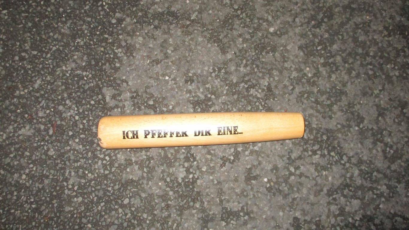 Ein Baseballschläger mit abgerochenem Griff und der Inschrift "Ich pfeffer dir eine..." liegt auf dem Boden: Damit soll ein bisher noch Unbekannter ein Auto in Hagen beschädigt haben.