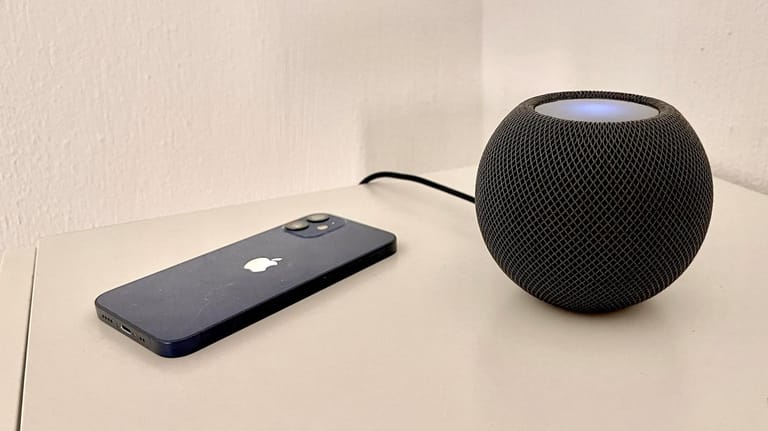 Der HomePod Mini neben einem iPhone 12 mini: Der neue Smartspeaker wird Apple-Fans glücklich machen.