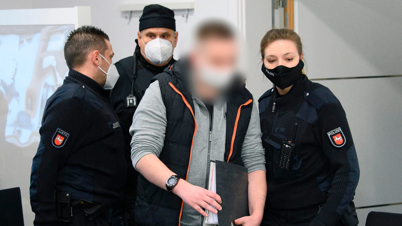 Prozess in Einbeck: Einer der beiden Angeklagten (m.) kommt mit Mund-Nasen-Schutz in den Sitzungssaal des Amtsgerichts.
