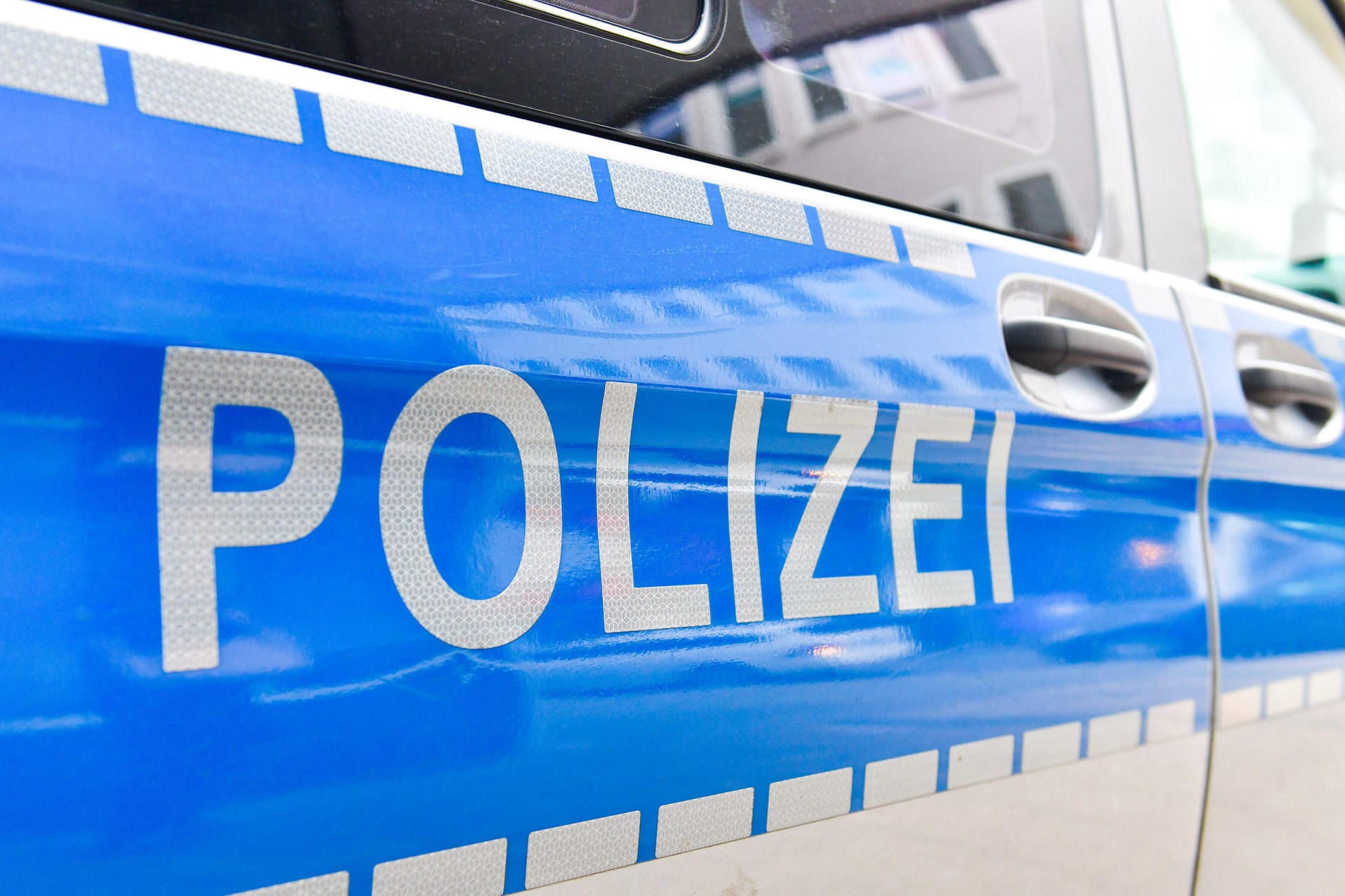 Schriftzug auf einem Polizeiauto (Symbolbild): Die Polizei sucht nach einer sexuellen Belästigung nach dem Täter.