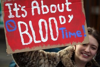 Eine Frau in Edinburgh hält bei einer Kundgebung ein Schild mit der Aufschrift "It's about bloody time!" (dt.