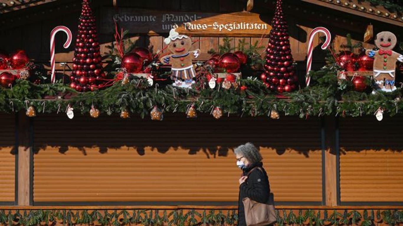 Eine Frau geht an einem weihnachtlich geschmückten Stand vorbei (Symbolbild): In Stuttgart startet der "Adventszauber".