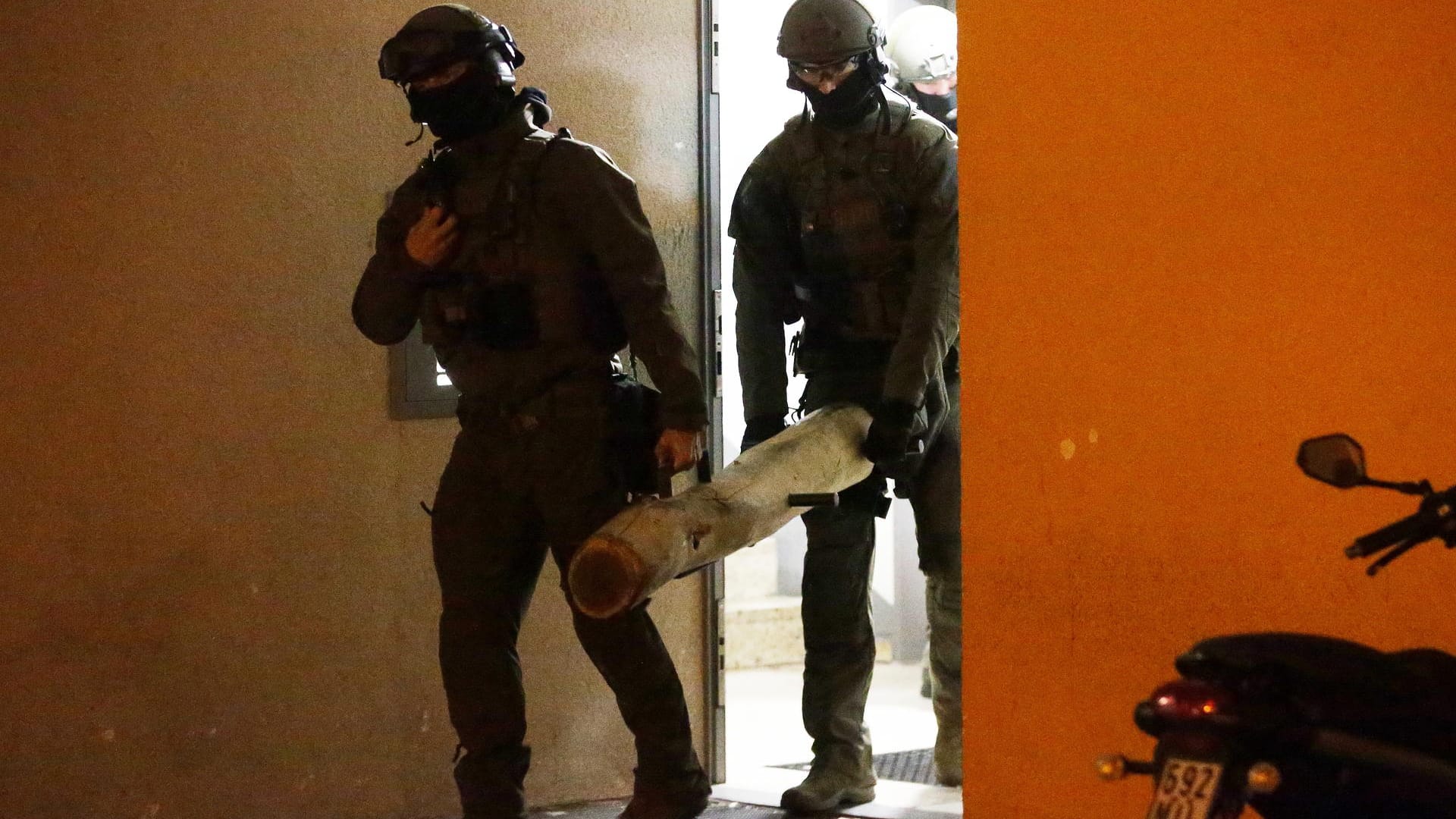 Polizisten vom SEK verlassen ein Mehrfamilienhaus und tragen dabei eine Ramme, zum Öffnen von Türen: Ein Düsseldorfer wurde wegen des Verdachts auf Besitz und Verbreitung von Kinderpornografie festgenommen.