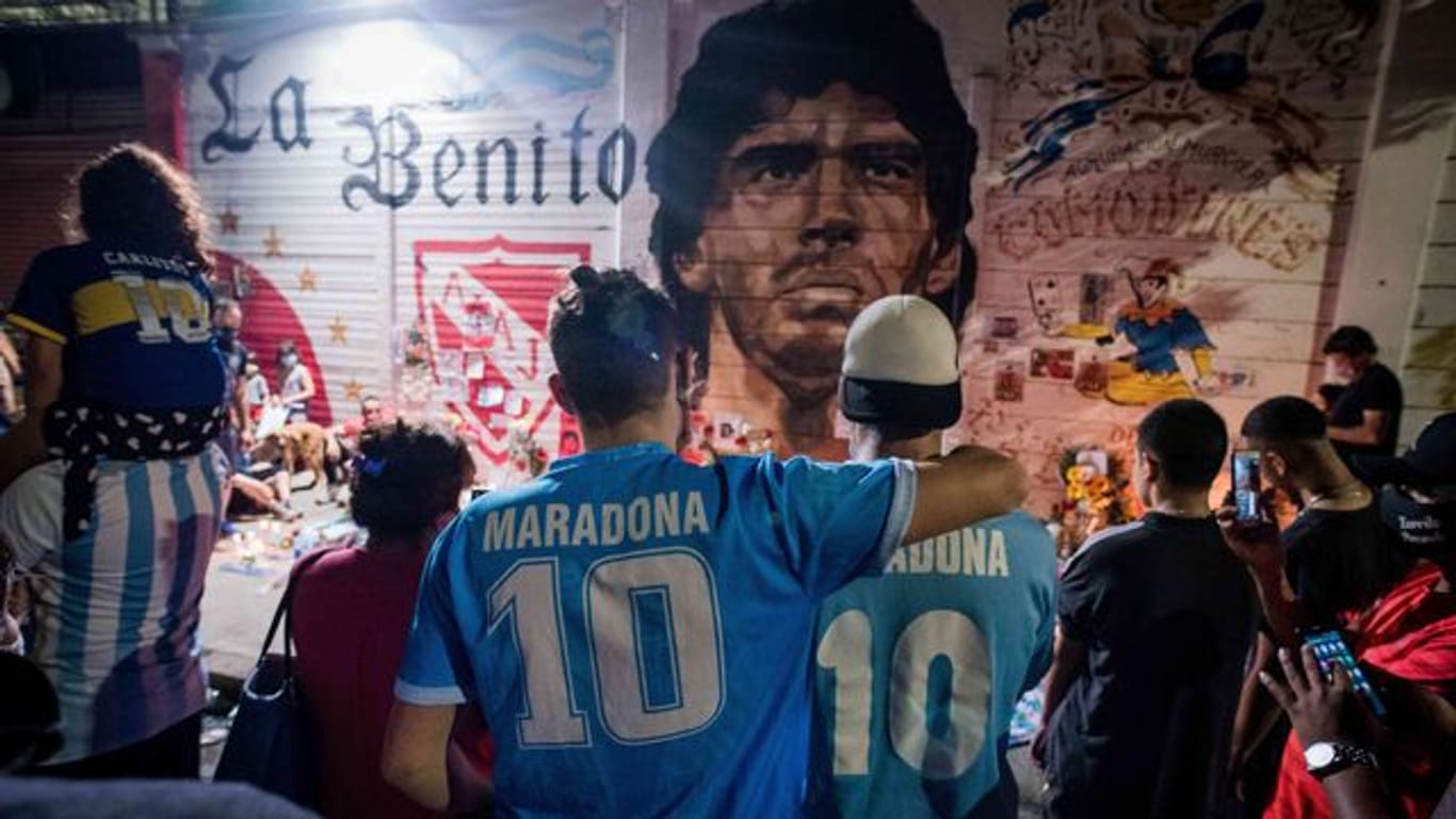 Argentinier versammeln sich vor einem Wandbild von Maradona.