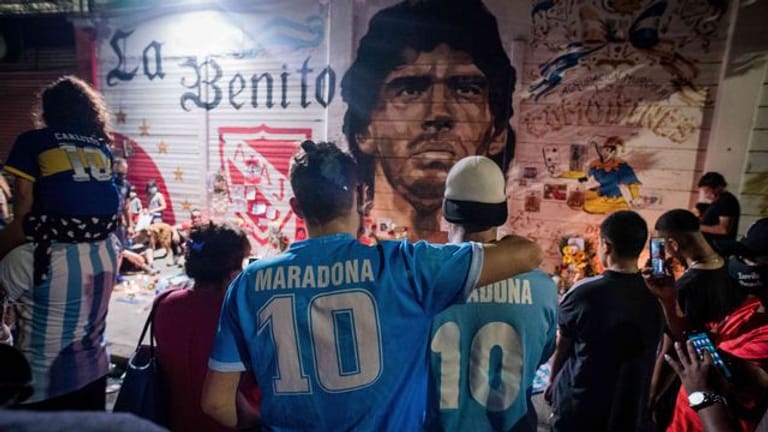 Argentinier versammeln sich vor einem Wandbild von Maradona.