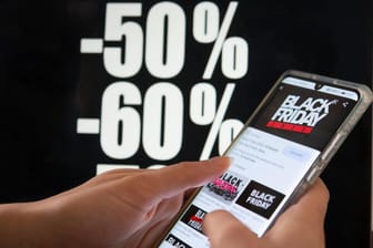 Eine Illustration zeigt ein Handy mit "Black Friday"-Schriftzügen (Symbolbild): Das Shopping-Event zieht auch viele Betrüger an, warnt die Hagener Polizei.