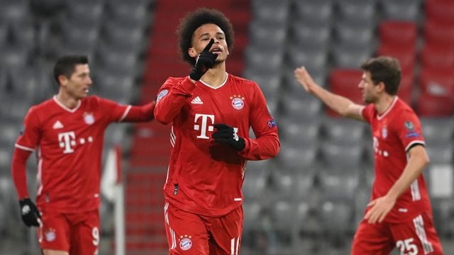 Leroy Sané (M) feiert sein Tor zum 3:0 für den FC Bayern, während hinter ihm Robert Lewandowski (l) und Thomas Müller abklatschen.