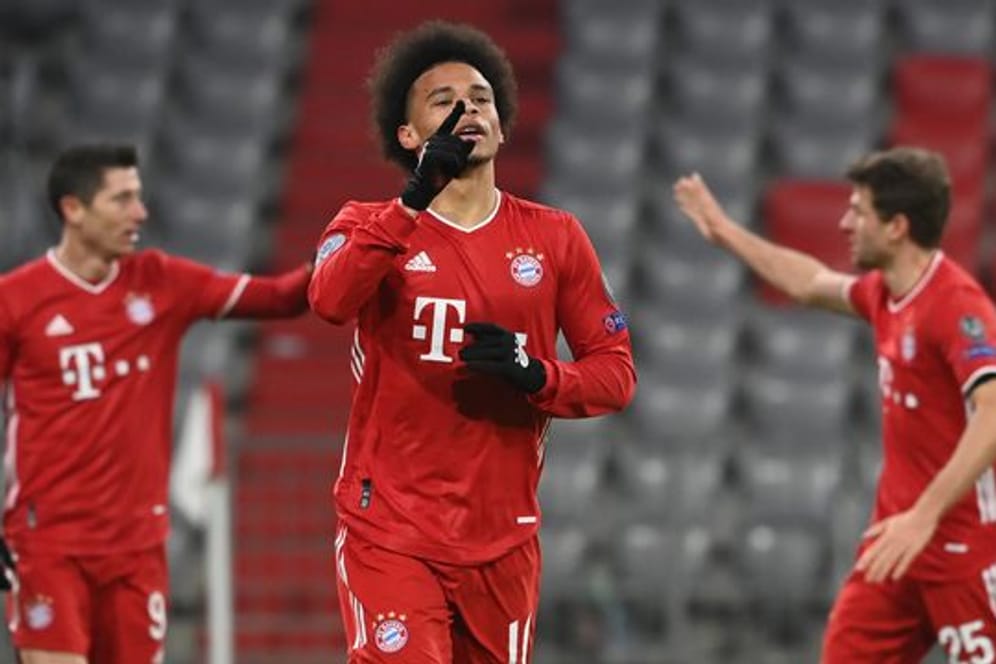 Leroy Sané (M) feiert sein Tor zum 3:0 für den FC Bayern, während hinter ihm Robert Lewandowski (l) und Thomas Müller abklatschen.