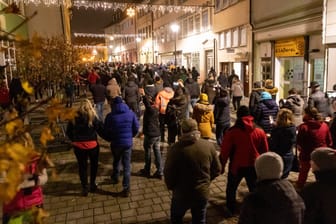 Thüringen, Hildburghausen: Menschen laufen durch die Innenstadt und protestieren gegen die neuen Infektionsschutzregeln in dem Kreis.
