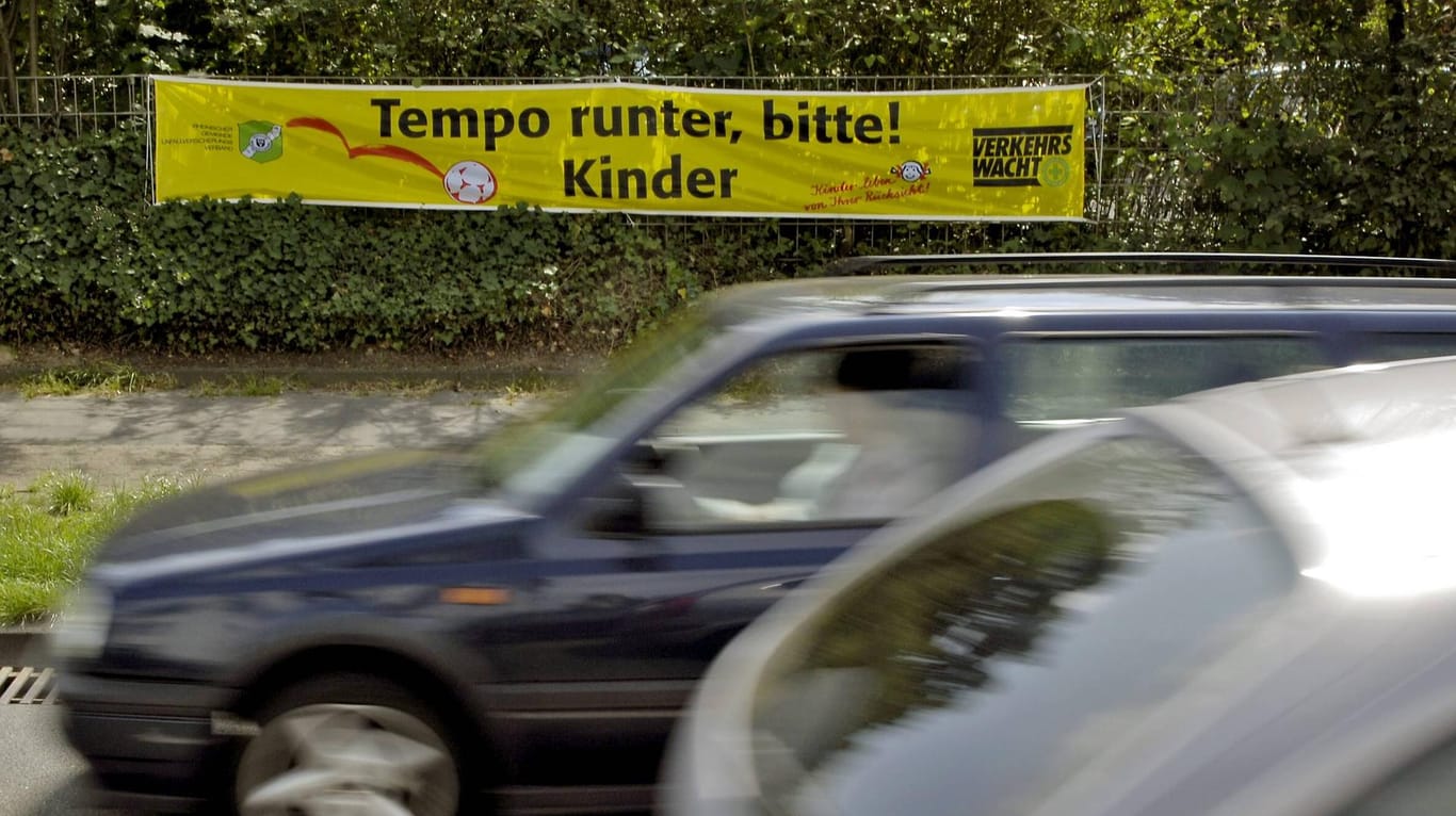 Ein Schriftzug mit "Tempo runter, bitte! Kinder hängt an einer Straße (Symbolbild): In Dortmund und Lünen fuhren laut Polizei hunderte Autofahrer im November an Schulen zu schnell.