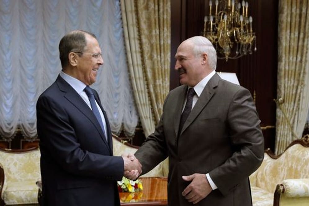 ARCHIV - Sergej Lawrow (l), Außenminister von Russland, schüttelt die Hand von Alexander Lukaschenko, Präsident von Belarus.