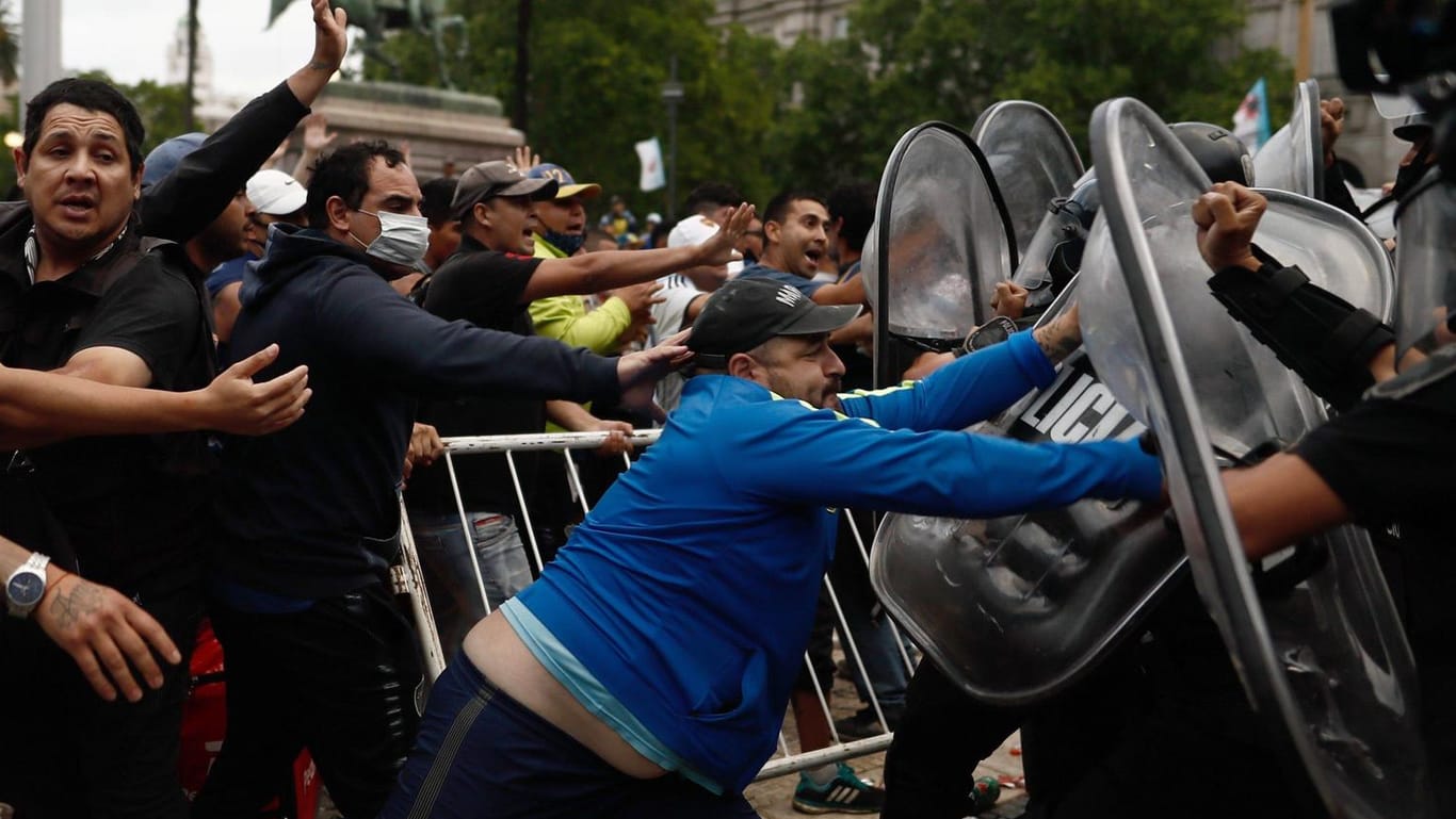 Maradona-Anhänger attackieren die Polizei, die sich um die wartende Menge positioniert hat.