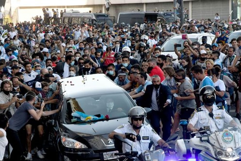 Nach dem Tod von Diego Maradona verlässt der Leichenwagen mit den sterblichen Überresten das Regierungsgebäude - begleitet von zahlreichen Fans.