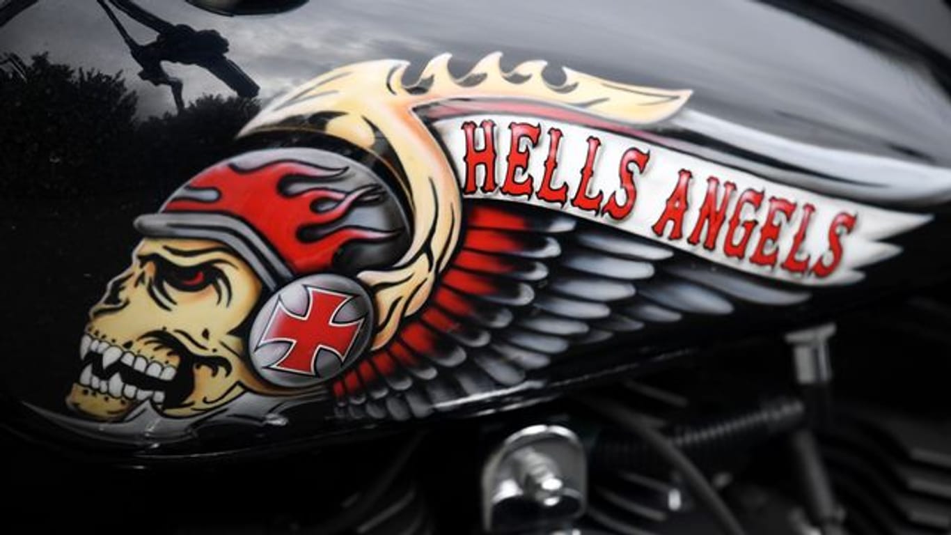 Das Hells Angels-Emblem, ein Totenkopf mit Helm und Flügeln, auf einem Tank eines abgestellten Motorrads.