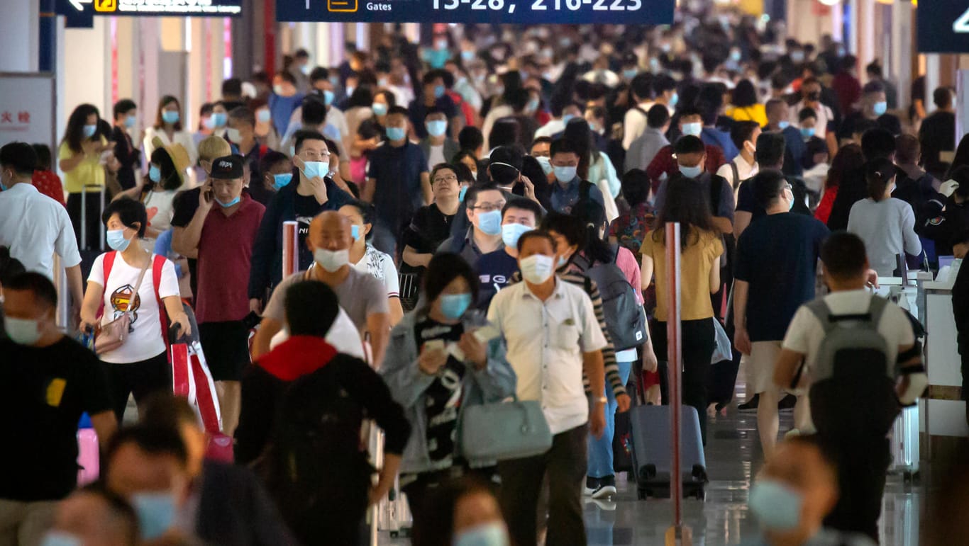 Fluggäste, die zum Schutz vor dem Coronavirus Gesichtsmasken tragen, gehen durch eine Halle des internationalen Flughafens Haikou Meilan in der südchinesischen Provinz Hainan.