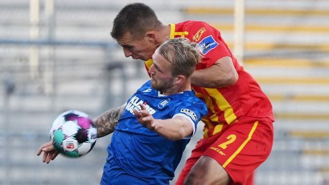 Der Karlsruher Philipp Hofmann (l) und Uwe Hünemeier vom KSC kämpfen um den Ball.