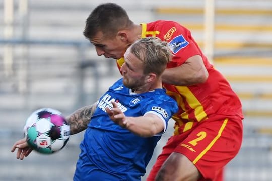 Der Karlsruher Philipp Hofmann (l) und Uwe Hünemeier vom KSC kämpfen um den Ball.