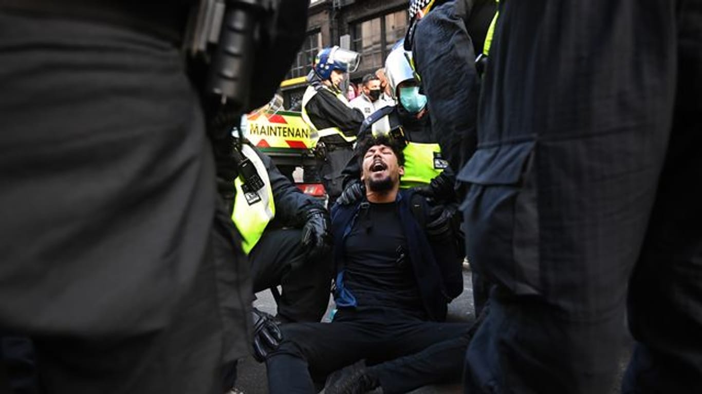Die Polizei verhaftet einen Demonstranten.