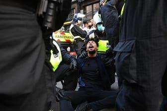 Die Polizei verhaftet einen Demonstranten.
