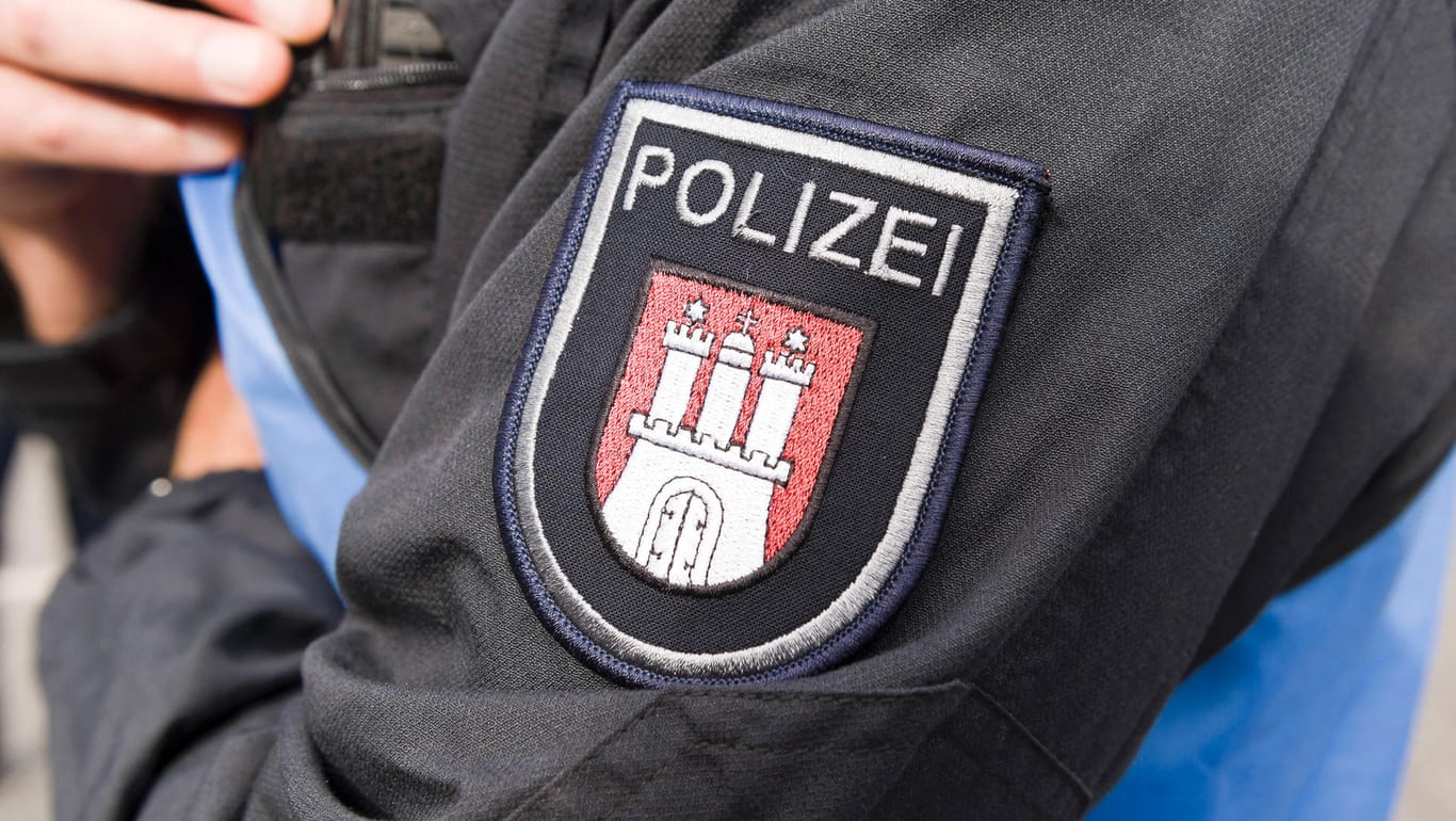 Polizeiwappen von Hamburg auf einer Polizeiuniform: In Billstedt soll ein Friseur einen Kunden attackiert haben.