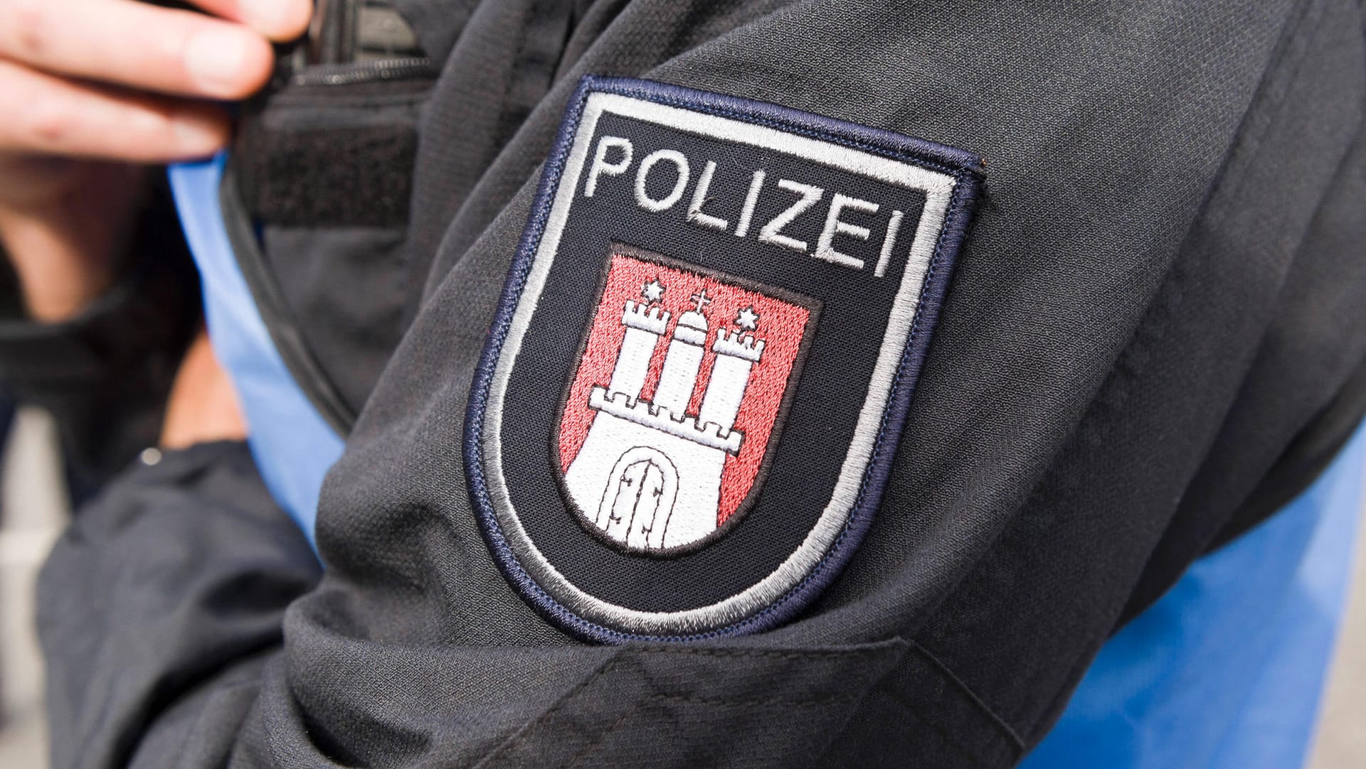 Polizeiwappen von Hamburg auf einer Polizeiuniform: In Billstedt soll ein Friseur einen Kunden attackiert haben. Polizeiwappen von Hamburg auf einer Polizeiuniform: In Billstedt soll ein Friseur einen Kunden attackiert haben.