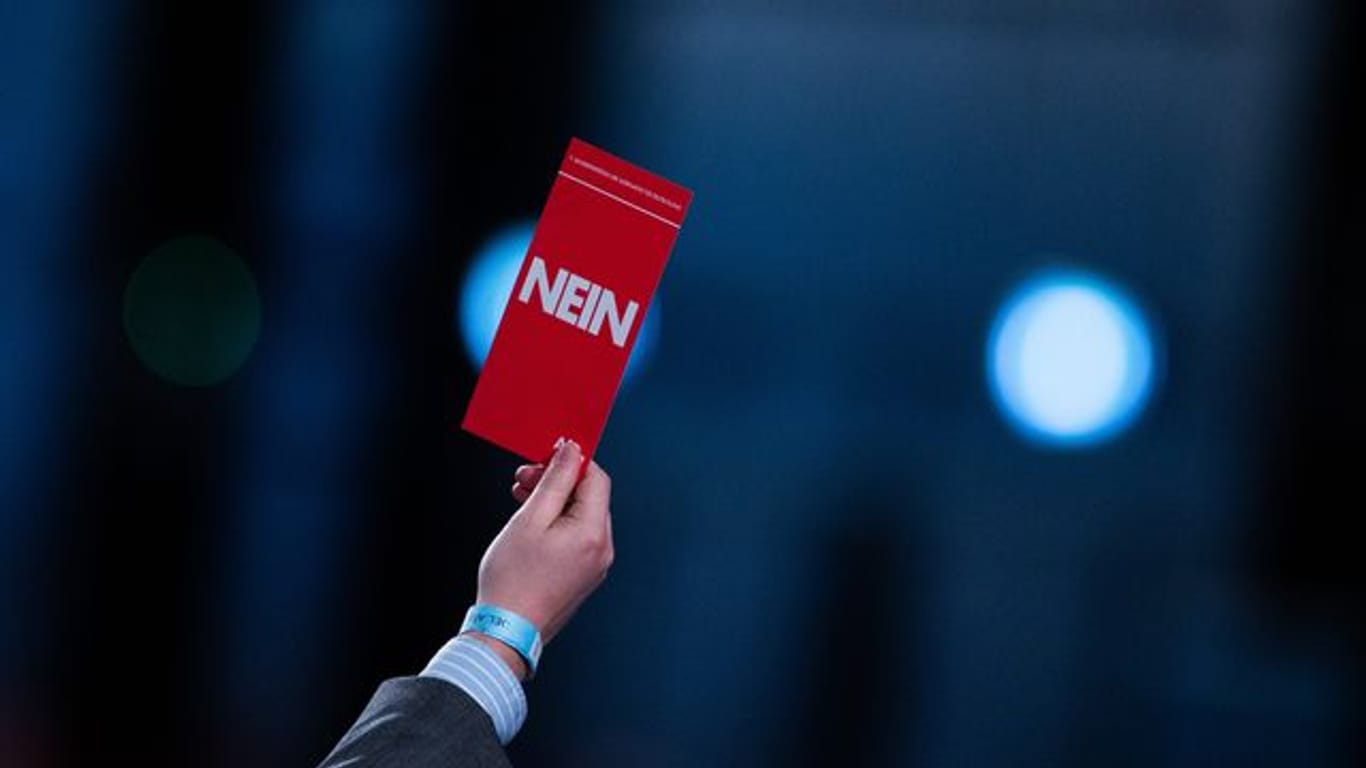 Einige Delegierte heben ihren Stimmzettel mit der Aufschrift "Nein" nach der Rede von Jörg Meuthen beim Bundesparteitag der AfD.