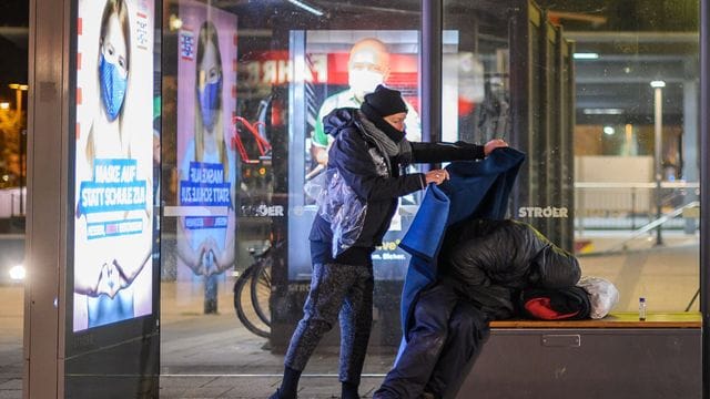 Die Sozialarbeiterin Elfi Ilgmann-Weiß legt einem schlafenden Obdachlosen eine Decke über: Viele Hilfsbedürftige kennt sie schon seit Jahren.