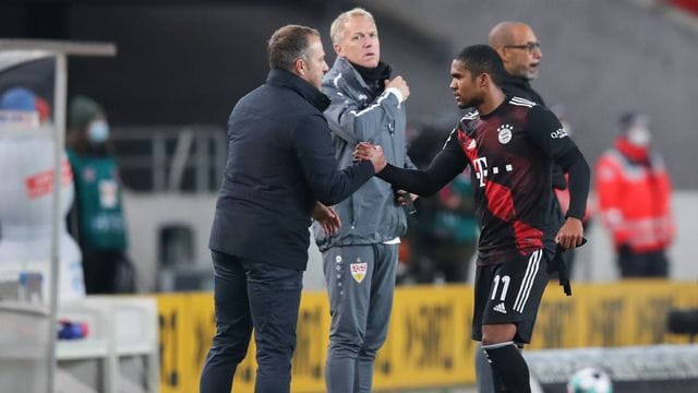 Bayern-Trainer Hansi Flick (l) klatscht sich nach dem Spiel mit Douglas Costa ab.