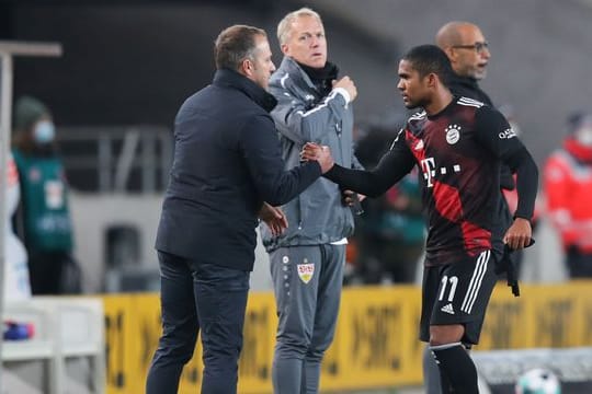 Bayern-Trainer Hansi Flick (l) klatscht sich nach dem Spiel mit Douglas Costa ab.