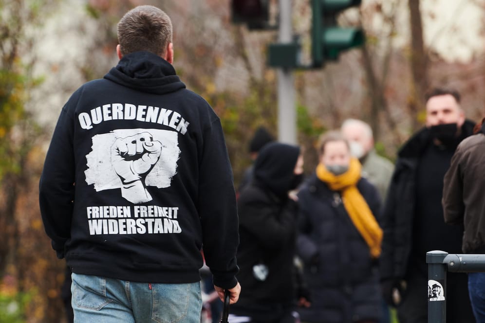 Mann mit "Querdenken"-Schriftzug auf der Oberkleidung (Archivbild): Der Verfassungsschutz will "Querdenken" noch nicht beobachten.