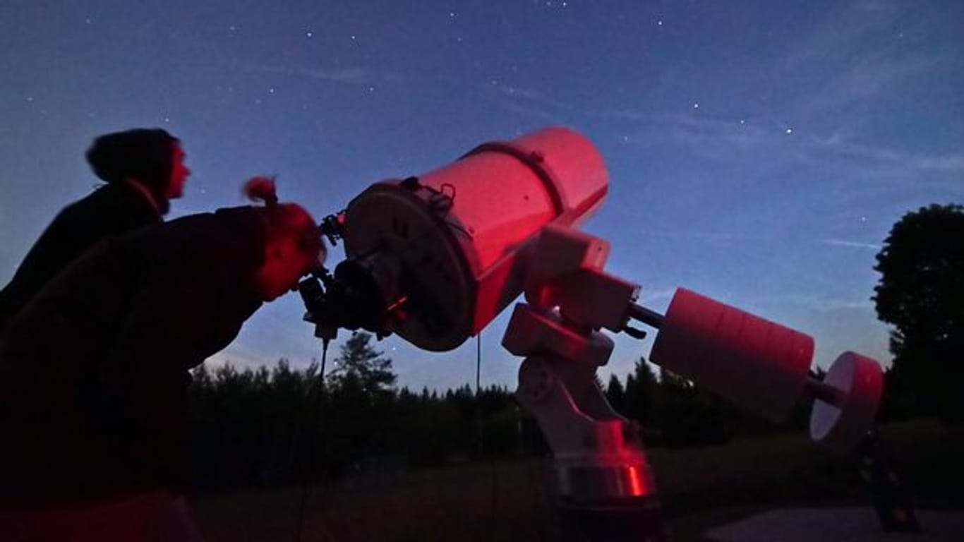 Das Archivfoto zeigt Sternegucker mit einem Teleskop.
