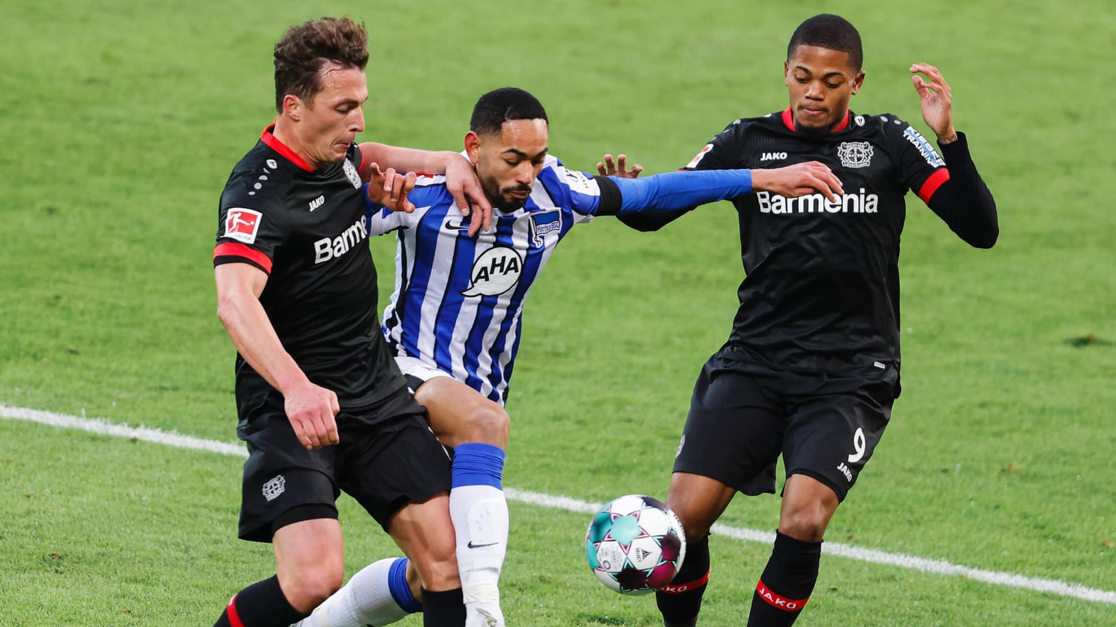 Bayers Julian Baumgartlinger (l.) im Duell mit Herthas Matheus Cunha (m.): Die Partie in Leverkusen war umkämpft.