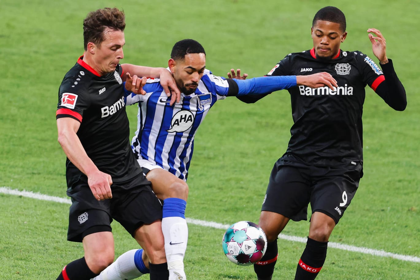 Bayers Julian Baumgartlinger (l.) im Duell mit Herthas Matheus Cunha (m.): Die Partie in Leverkusen war umkämpft.