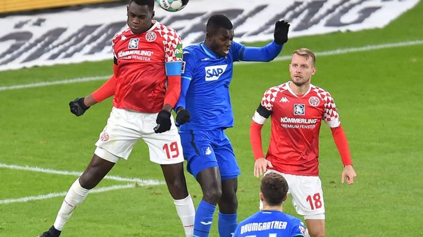 Der Mainzer Moussa Niakhate (l) im Kopfballduell mit Hoffenheims Ihlas Bebou.