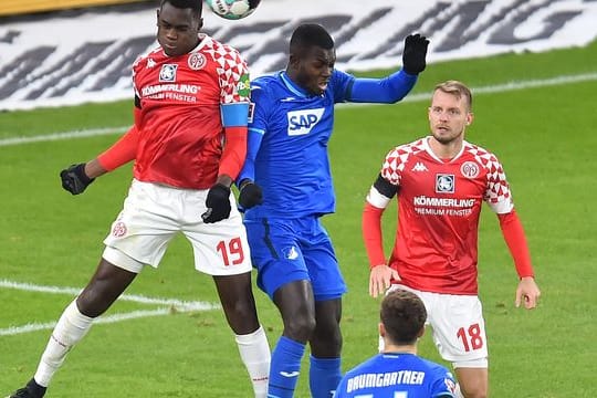 Der Mainzer Moussa Niakhate (l) im Kopfballduell mit Hoffenheims Ihlas Bebou.
