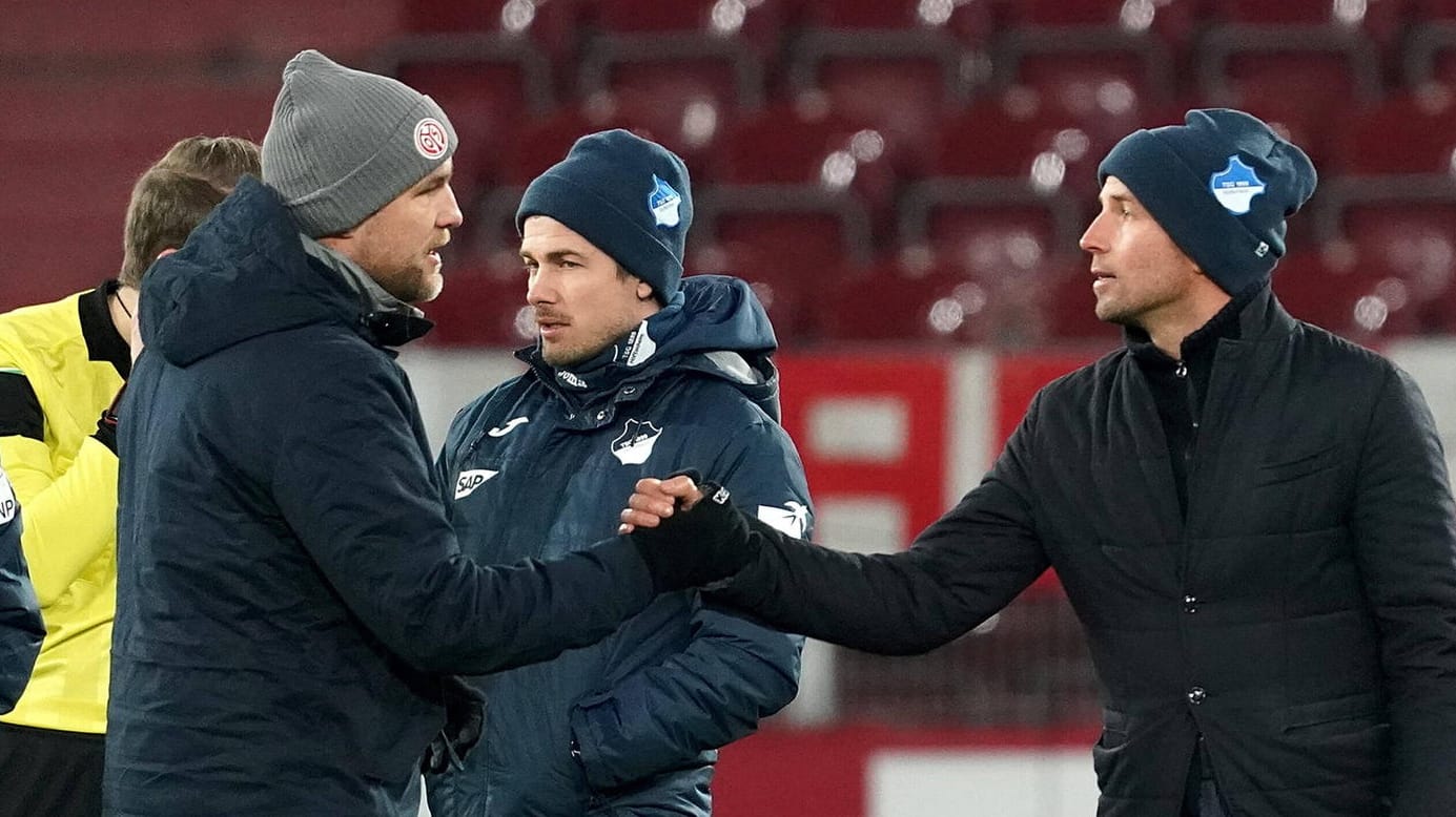 Hoffenheim-Coach Sebastian Hoeneß gibt Mainz-Sportdirektor Rouven Schröder nach der umkämpften Partie die Hand (v.r.). Hoffenheim-Coach Sebastian Hoeneß gibt Mainz-Sportdirektor Rouven Schröder nach der umkämpften Partie die Hand (v.r.).