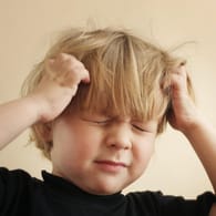 Kind kratzt sich am Kopf: Besonders in Schulen und Kindergärten verbreiten sich Kopfläuse besonders schnell.