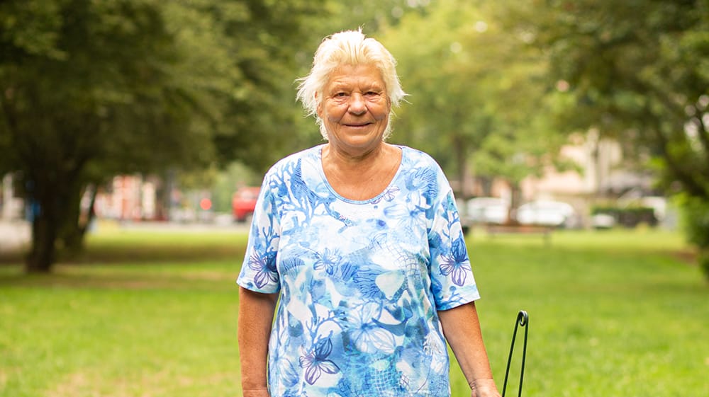 Ilona Ochs seht mit einem Müllpicker auf einer Wiese in Köln: Sie mag es sauber und ordentlich – und bringt sich ehrenamtlich in Holweide ein.