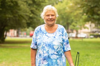 Ilona Ochs seht mit einem Müllpicker auf einer Wiese in Köln: Sie mag es sauber und ordentlich – und bringt sich ehrenamtlich in Holweide ein.