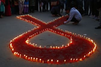 Eine rote Schleife aus Kerzen vor dem Welt-Aids-Tag