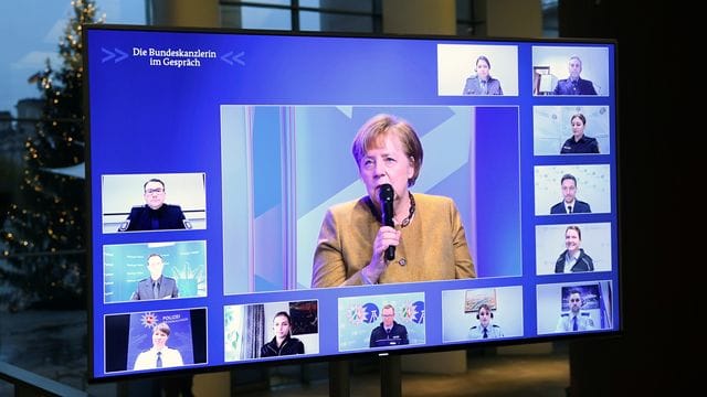 Kanzlerin Angela Merkel spricht mit Polizeibeamten und Polizeibeamtinnen.