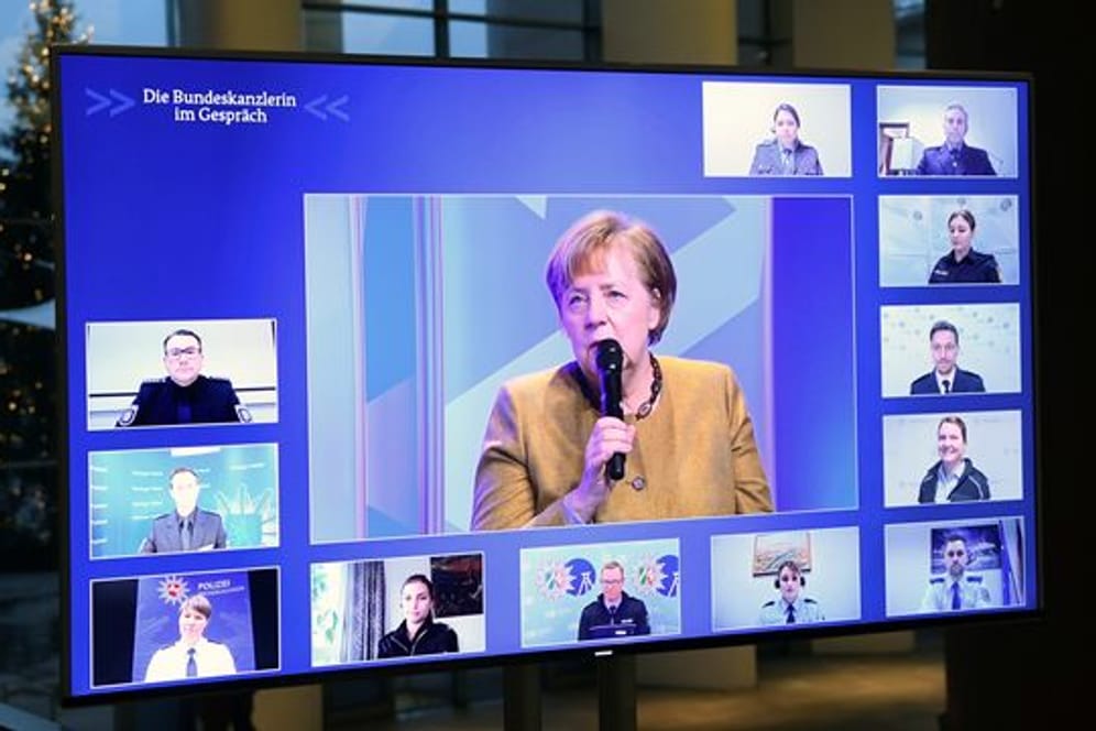 Kanzlerin Angela Merkel spricht mit Polizeibeamten und Polizeibeamtinnen.