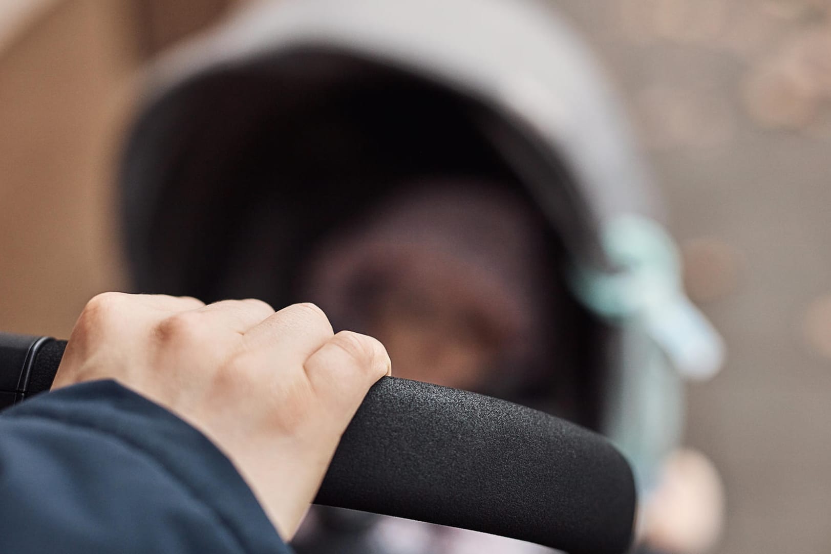 Hand an Kinderwagen: Der Vater war mit seinem Sohn im Kinderwagen unterwegs, als der diesen in dem Fluss warf (Symbolbild).