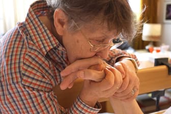 Frau küsst die Hand ihres Mannes: Forscher konnten offenbar eine Methode zur Früherkennung von Alzheimer entwickeln.