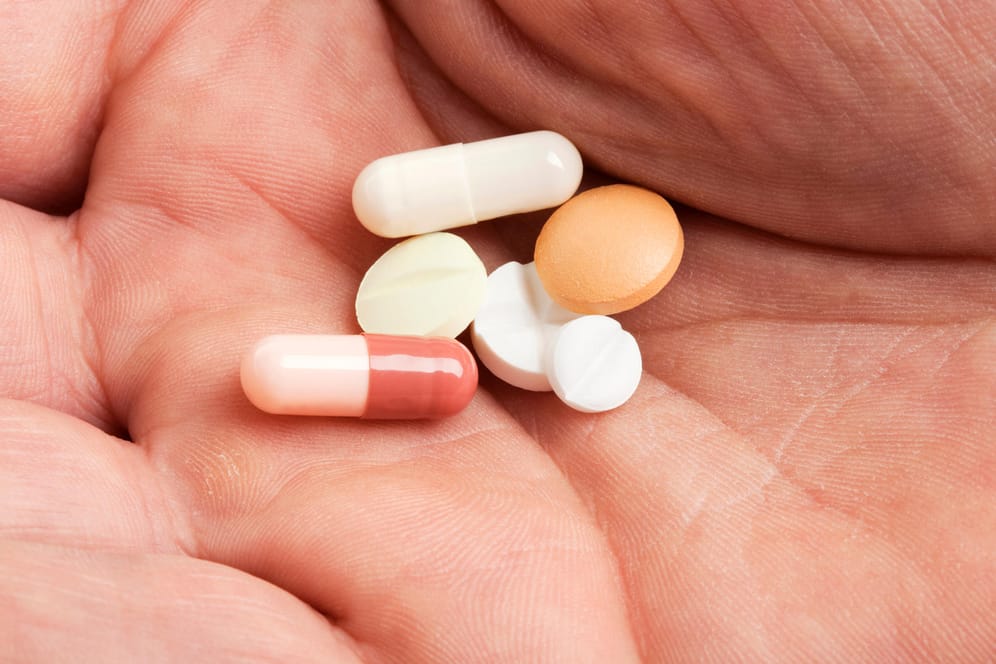 Pillen,Tabletten und Kapseln liegen in einer Hand. Cholesterinsenkende Medikamente stehen bei vielen Patienten in einem schlechten Ruf. Zu Unrecht, sagen Experten.