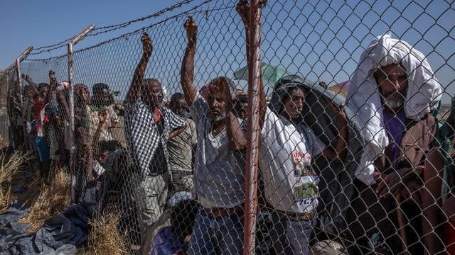 Geflüchtete Menschen aus der Region Tigray warten vor dem "Hamdayet Transition Center" auf Decken, die von dem UN-Flüchtlingshilfswerk UNHCR ausgegeben werden. Geflüchtete Menschen aus der Region Tigray warten vor dem "Hamdayet Transition Center" auf Decken, die von dem UN-Flüchtlingshilfswerk UNHCR ausgegeben werden.