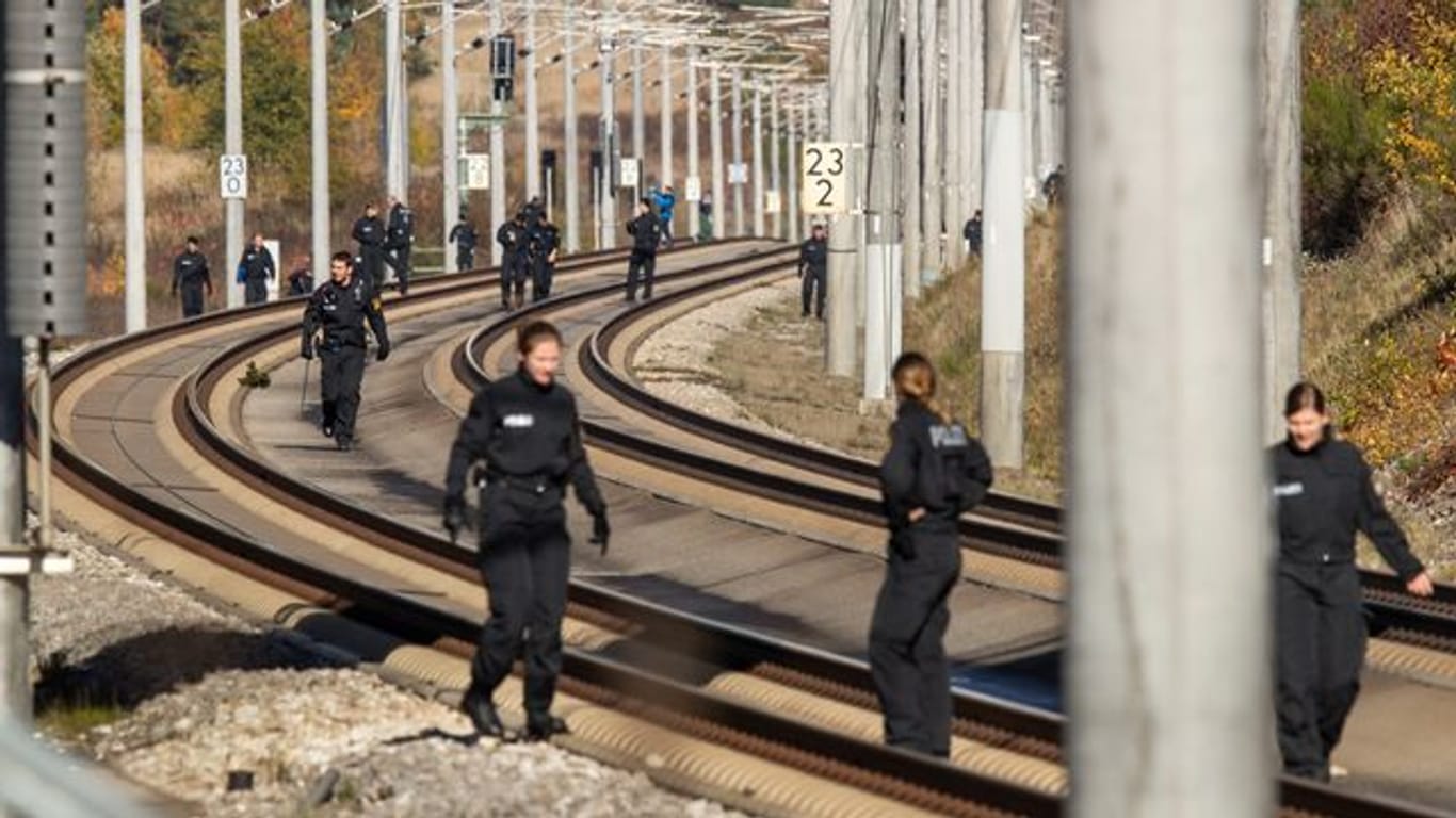 Polizistinnen und Polizisten suchen im Oktober 2018 auf der ICE-Strecke zwischen Nürnberg und München die Schienen ab.