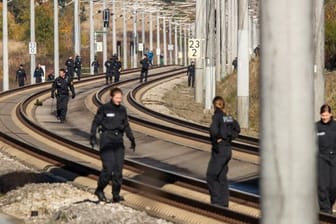 Polizistinnen und Polizisten suchen im Oktober 2018 auf der ICE-Strecke zwischen Nürnberg und München die Schienen ab.